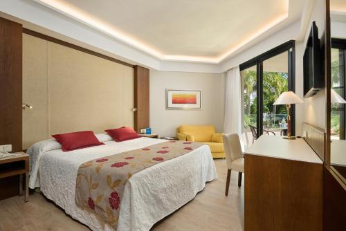 a bedroom with a bed and a living room at Hipotels Sherry Park in Jerez de la Frontera