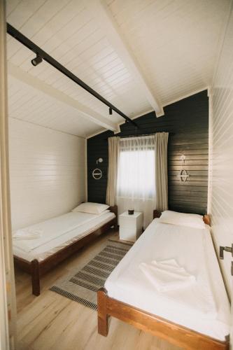 a bedroom with two beds and a window at Szépasszony Guest House in Vlăhiţa