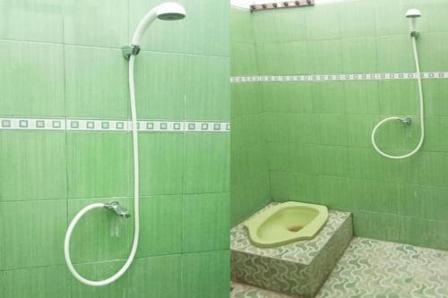 baño verde con aseo y ducha en SPOT ON 3605 Clarichie Guest House, en Kupang