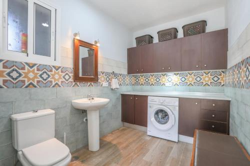 een badkamer met toilet, wastafel en wasmachine bij Casa rural Villa Moral in El Arahal