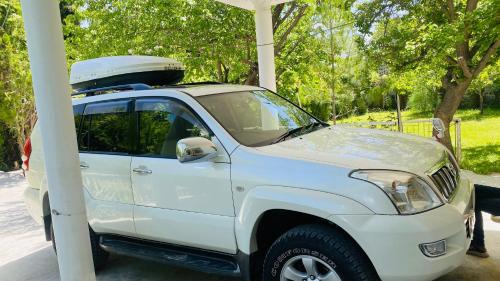 a white truck with a surfboard on top of it at Skardu Baltistan Village Guest House in Skardu