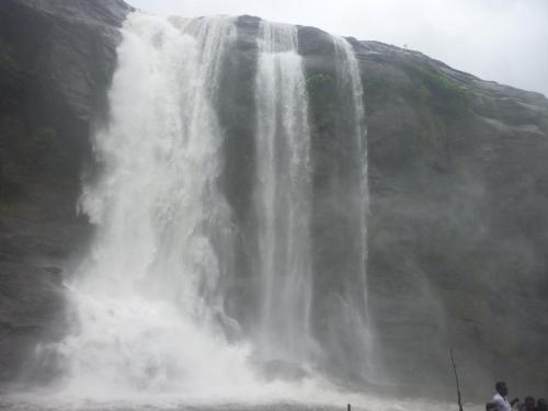 a waterfall with people standing in front of it at Jojies Homestay Fortkochi in Cochin