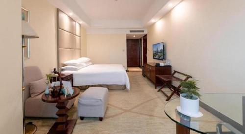 a large hotel room with a bed and a table at New Century Grand Hotel Zhuji Yaojiang in Shaoxing