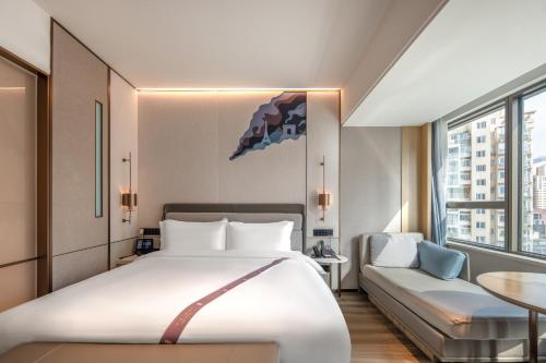 a hotel room with a large bed and a table at Shanghai Elong Hotel by the bund and Nanjing road Pedestrian street in Shanghai