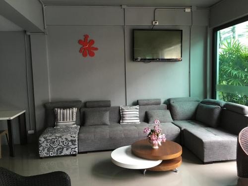 a living room with a couch and a tv at Chalong Sea Breeze in Chalong 