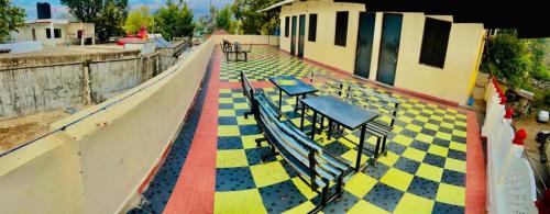 Una vista de un piso de baldosas con bancos en un edificio. en Hotel Radhika Palace, en Mount Abu