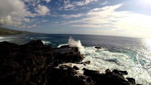 a wave crashing on the rocks near the ocean at Bungalow Pointe Châteaux St Leu ocean view, pool in Saint-Leu