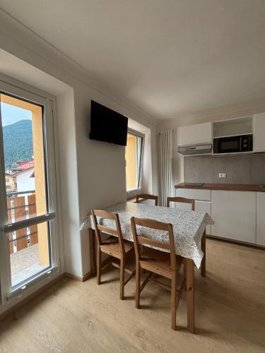 a dining room with a table and chairs and a window at Tre Cime Apartments - monolocali in Auronzo di Cadore