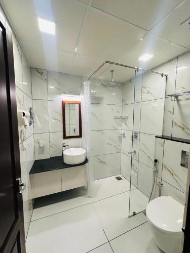 a bathroom with a toilet and a sink and a shower at Hotel Laals Inn Grand By Jesway Hotels and Resorts in Cochin