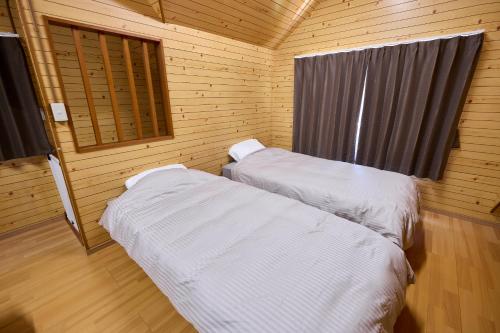 a room with two beds in a wooden cabin at WATERSIDE Base 鹿嶋 北浦 in Kashima