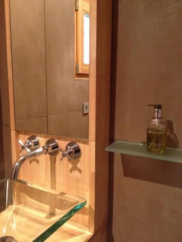 La salle de bains est pourvue d'un lavabo et d'une bouteille de savon. dans l'établissement Lakeview 180°, à Talloires