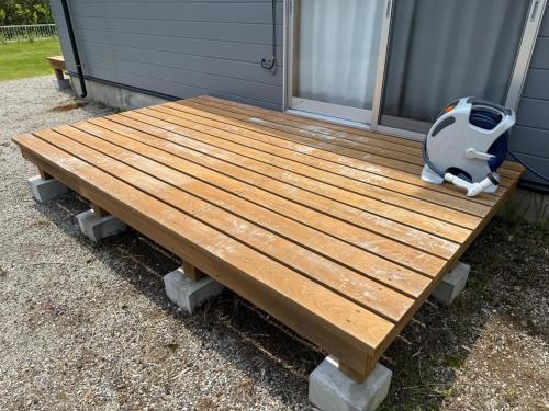 a wooden picnic table sitting outside of a house at WATERSIDE Base 鹿嶋 北浦 in Kashima