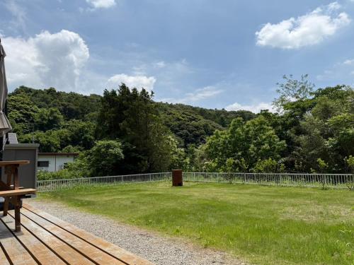a view of a field with a fence and trees at WATERSIDE Base 鹿嶋 北浦 in Kashima