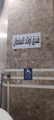 a sign on the wall of a bathroom at Sultan awtadHotel فندق اوتاد السلطان العزيزية in Makkah