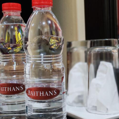 two bottles of water sitting on top of a table at DANA HOTEL-Clock Tower Sharjah in Sharjah