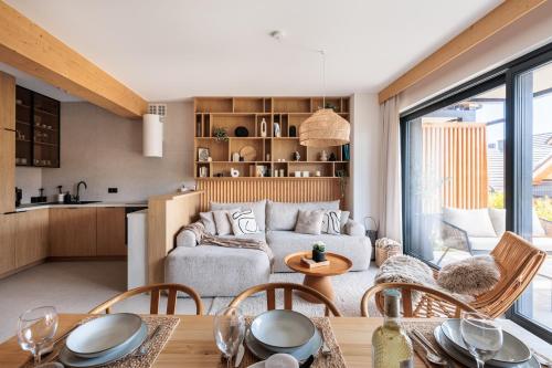 a living room with a couch and a table at Stylchyn Park - Czorsztyn Exclusive - by Upstairs in Kluszkowce