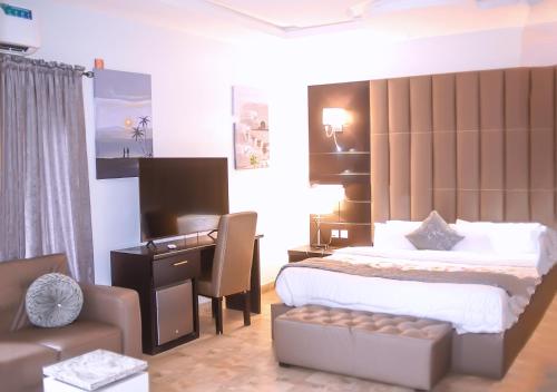 a bedroom with a bed and a desk and a chair at Mainstay Luxury Hotel in Ibadan