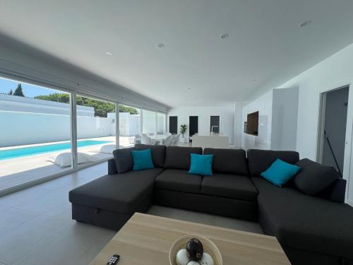 a living room with a black couch and blue pillows at El Paraiso in Hozanejos