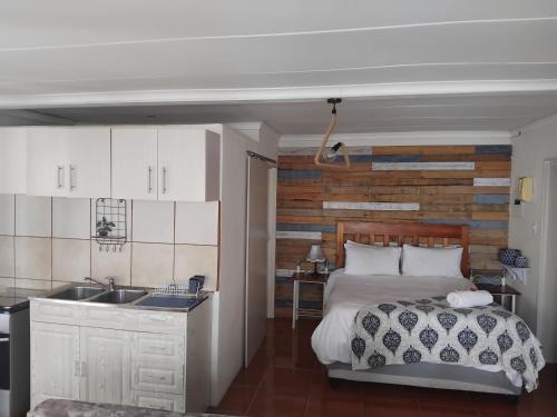 a kitchen and a bedroom with a bed and a sink at Country Route LTX in Lichtenburg