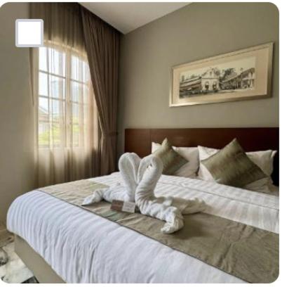 a bedroom with a large bed with a white comforter at Macalister Terraces Hotel in George Town
