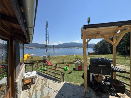 a backyard with a grill and a view of the water at Villa Raiski kyt in Dospat