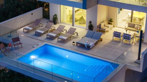 an overhead view of a swimming pool in a house at Luxurious VILLA LAPIS - heated pool, sauna, gym and spa, 120m to sandy beach in Omiš