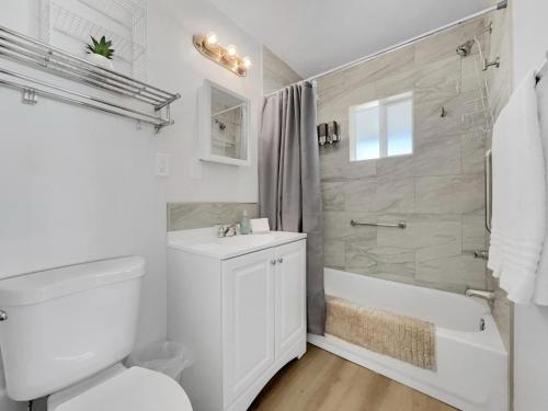 a white bathroom with a tub and a toilet and a sink at Drew 253 Mesa in Mesa