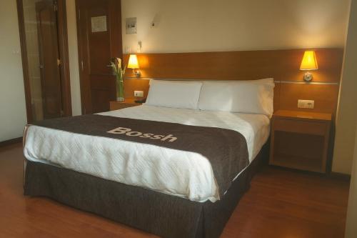 a large bed in a hotel room with two lamps at Hotel Avión by Bossh! Hotels in Vigo