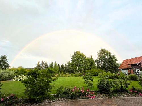 a rainbow in the sky over a garden at "Grüne Oase" in der Lüneburger Heide in Altenmedingen