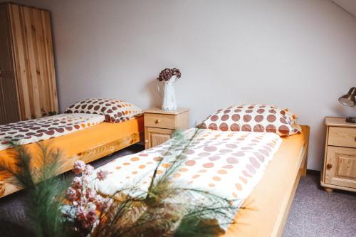 two twin beds in a room with a vase of flowers at Zámek Spálené Poříčí in Spálené Poříčí