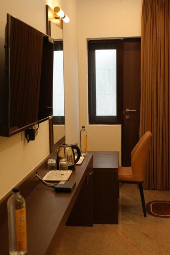 a hotel room with a desk with a phone and a chair at Jsm Residency Egmore in Chennai