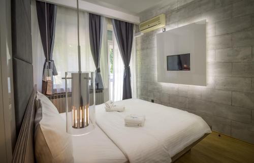 1 dormitorio con 1 cama con 2 toallas en Central Park Residence, en Belgrado