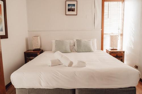 een wit bed met twee witte handdoeken erop bij #15 Tallow Sands - The Cabin in Suffolk Park