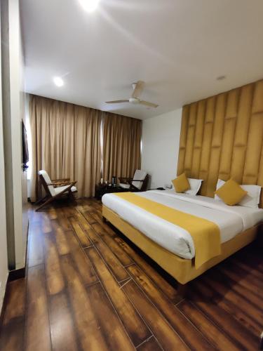 a bedroom with a large bed with a yellow blanket at Hotel Landmark in Chandīgarh