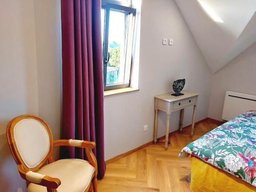 a bedroom with a bed and a window and a chair at Gîte Les Jacquemarts Normands in Belmesnil