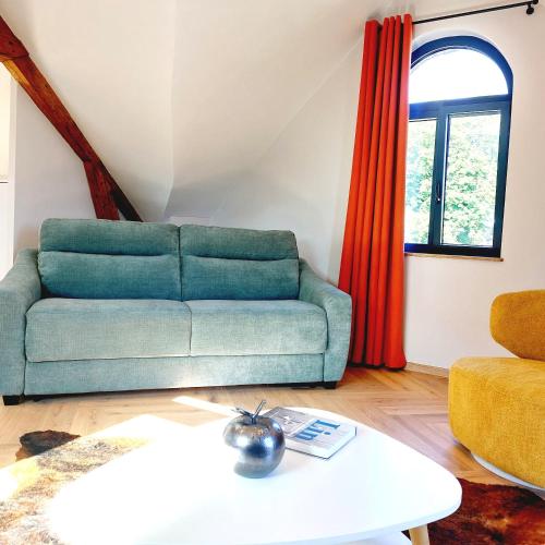 a living room with a couch and a table at Gîte Les Jacquemarts Normands in Belmesnil
