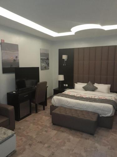 a bedroom with a bed and a desk and a piano at Mainstay Luxury Hotel in Ibadan