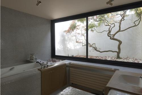 ein Badezimmer mit einem großen Fenster, einer Badewanne und einem Waschbecken in der Unterkunft Villa Sugulna in Saint-Pierre-dʼIrube