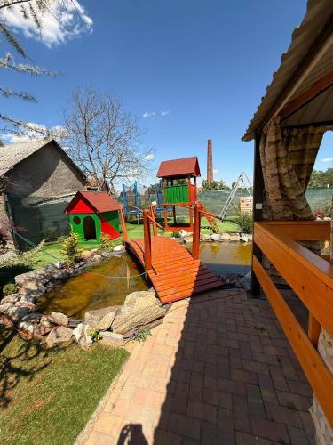 a playground with a slide and a play house at PENSIUNE RESTAURANT OVIDIU in Valea lui Mihai