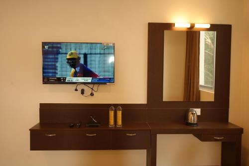 a bathroom with a television on a wall with a vanity at Jsm Residency Egmore in Chennai