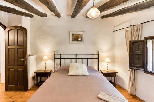 a bedroom with a bed with two tables and two lamps at El Revolt de Martís in Esponellá
