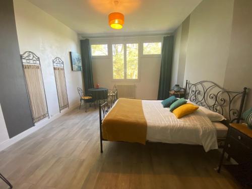 a bedroom with a bed with yellow pillows on it at Cosy Er Lann Chambres d'Hôtes in Val Couesnon