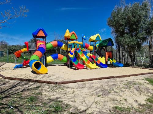 - une aire de jeux avec des équipements de jeux colorés dans un parc dans l'établissement Camping L'Evasion 4 etoiles, à Fontès