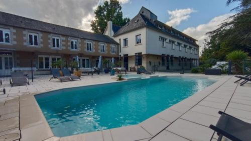 a large swimming pool in front of a building at Cosy Er Lann Chambres d'Hôtes in Val Couesnon