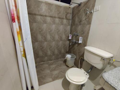 a small bathroom with a toilet and a shower at Hotel Landmark in Chandīgarh
