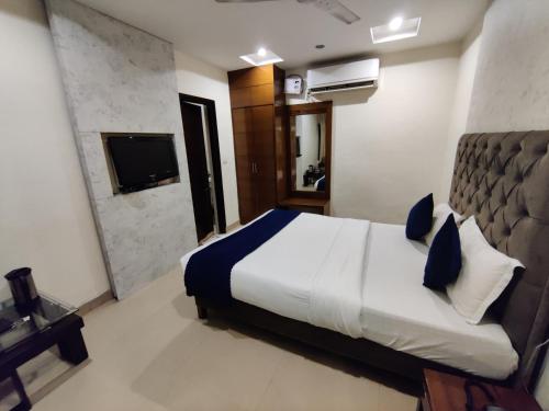 a hotel room with a bed and a television at Hotel Landmark in Chandīgarh