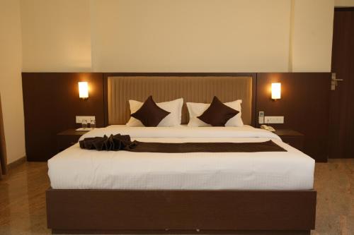 a bedroom with a large bed with black and white pillows at Jsm Residency Egmore in Chennai
