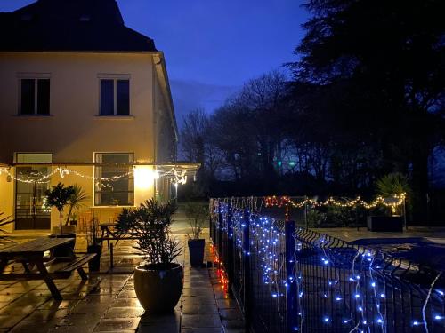 a fence with christmas lights in front of a building at Cosy Er Lann Chambres d'Hôtes in Val Couesnon