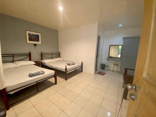 a room with two beds and a window at Marion Roos Hotel in Puerto Galera