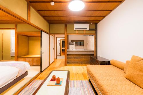 a living room with a bed and a couch at NIPPONIA Sado 佐渡相川 金山町 in Sado